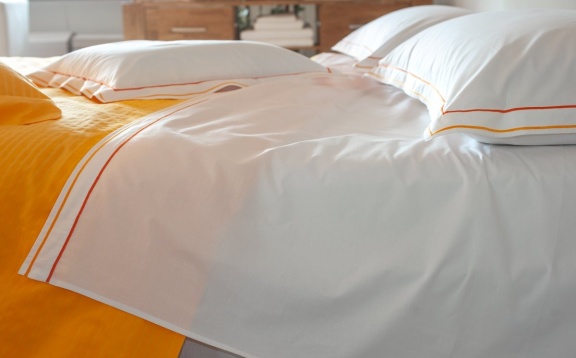 Cotton sheets plain with orange double "cordonetto" embroidery..