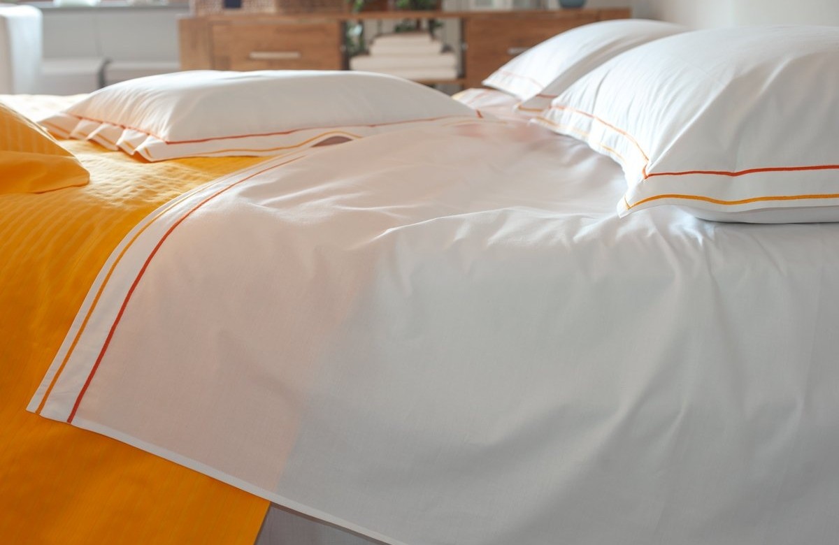 Cotton sheets plain with orange double "cordonetto" embroidery. Cotton sheets plain with orange double "cordonetto" embroidery.