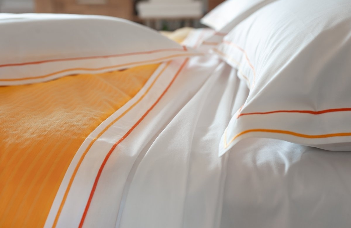 Cotton sheets plain with orange double "cordonetto" embroidery.
