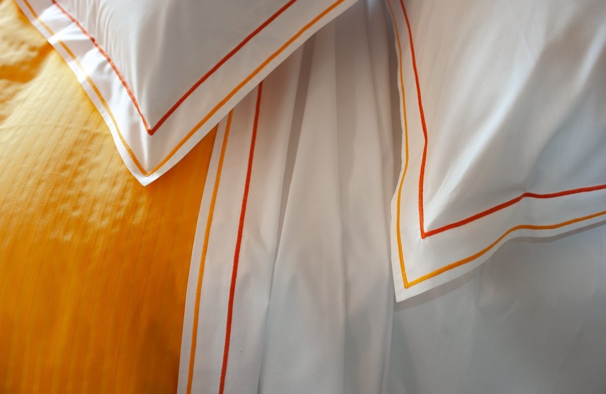 Cotton sheets plain with orange double "cordonetto" embroidery. Cotton sheets plain with orange double "cordonetto" embroidery.